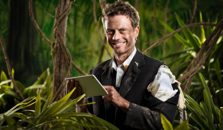 Mann i opprevet dress i jungelen med iPad